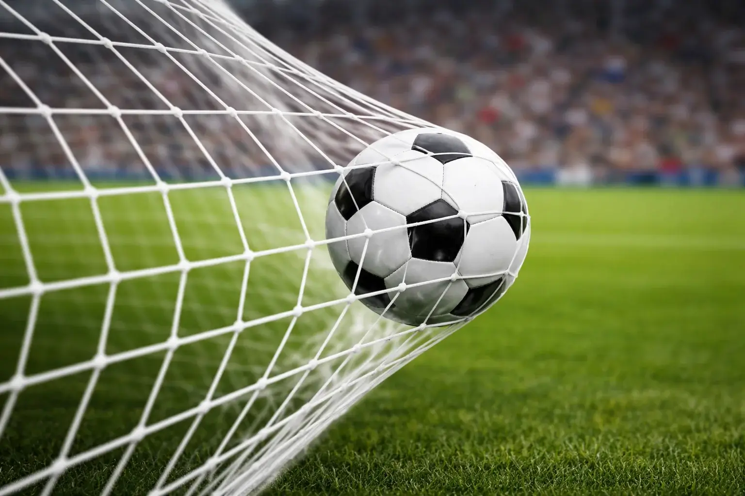 Voetballer scoort een doelpunt met bal in het doel