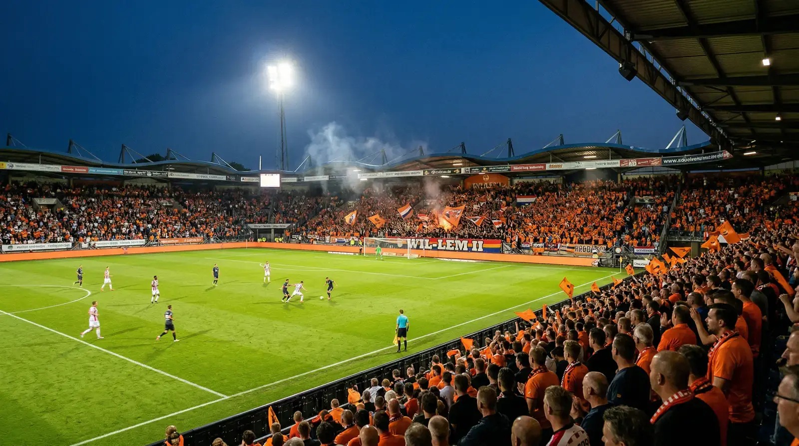 Nederlands voetbalstadion met groen veld en oranje accenten in de tribunes
