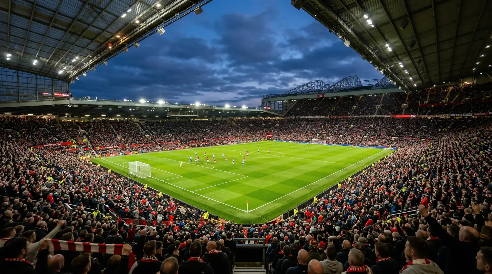 Druk Premier League stadion bij avondlicht met fel groen voetbalveld